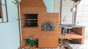 Ein Backofen aus Ziegelsteinen mit Fenster und Spüle darunter.