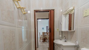 Ein Badezimmer mit Waschbecken, Spiegel und Handtuchhalter.