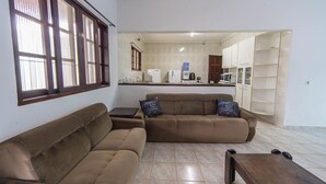 Ein Wohnzimmer mit braunen Sofas, einem Couchtisch und einem Billardtisch.