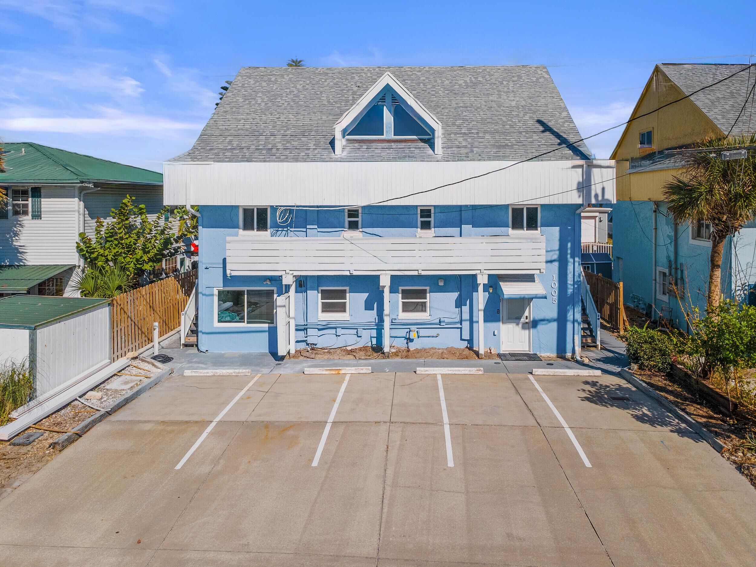 A two-story building with a gabled roof and a front parking lot.