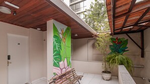 Un espace intérieur propre, carrelé, avec un banc en bois, une porte et une plante en pot.