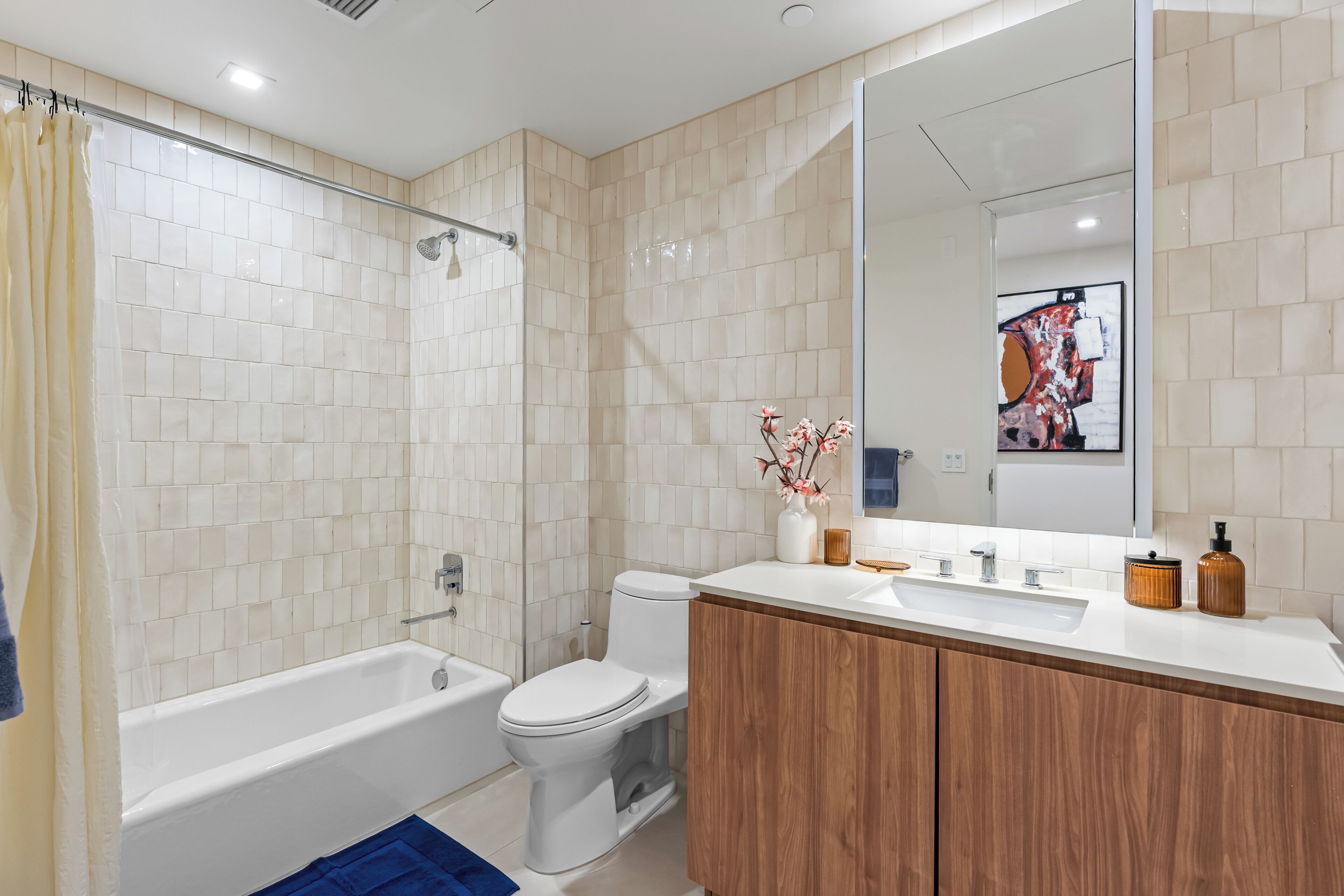A modern bathroom with a bathtub, toilet, and shower.