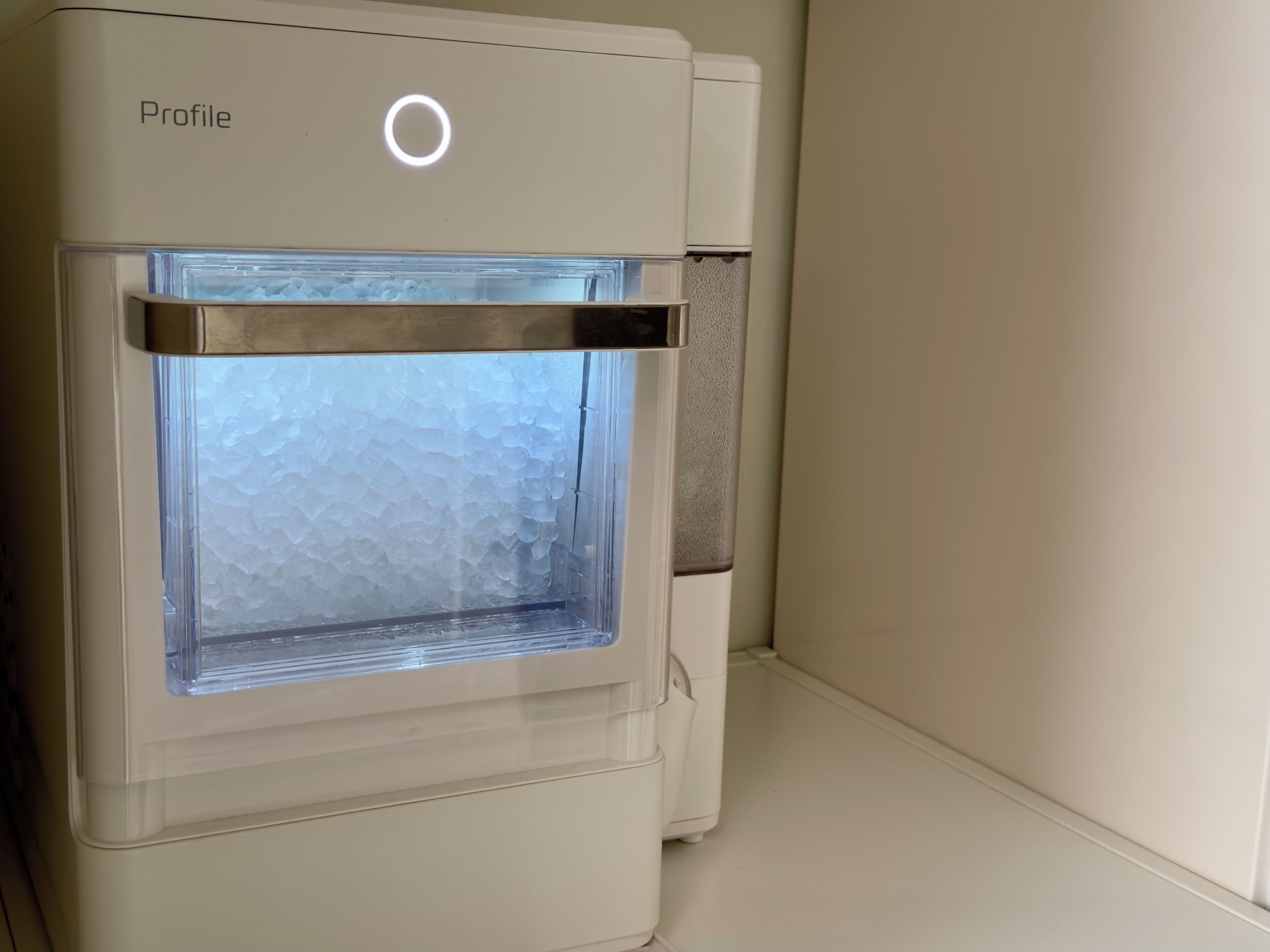 A water dispenser with a frosted glass panel and a circular light above it.
