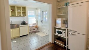 A compact kitchen with a refrigerator, microwave, and coffee maker. - Boutique Historic Stay • Best Downtown Location (Savannah)