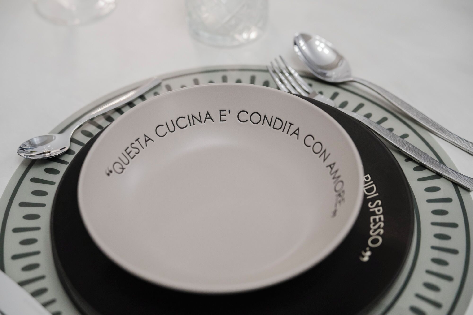 Une table à manger dressée avec une assiette, des couverts et un verre.