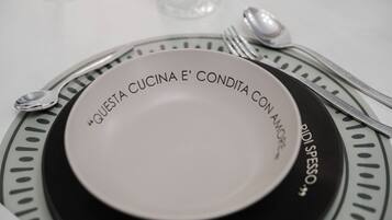 Une table à manger dressée avec une assiette, des couverts et un verre.