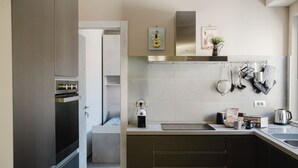 A modern kitchen with a built-in oven, a coffee machine, and a kettle on the counter. - La Boutique Apartment - Borgo Delle Colonne (Parma)