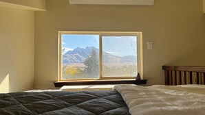 Ein Schlafzimmer mit einem großen Fenster und Blick auf die Berge.