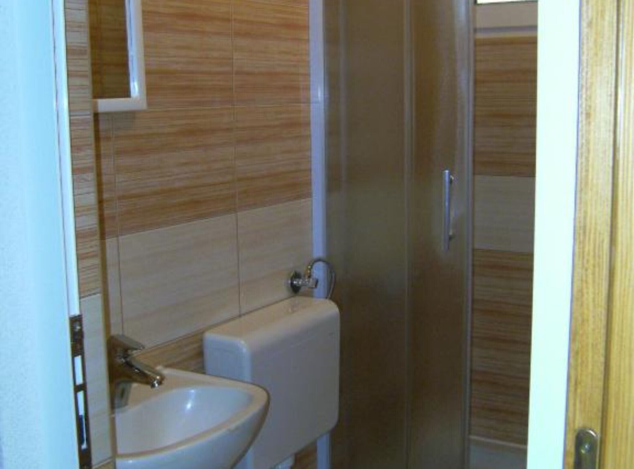 A bathroom with a sink, toilet, and shower area.