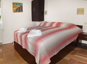 Une chambre à coucher avec un lit, une table de chevet, une armoire et un tableau au mur.