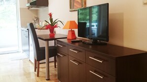 Eine moderne Küche mit Essbereich, einem Fernseher und einer roten Lampe auf einem Schrank.