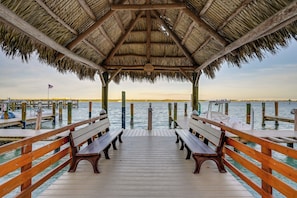 A wooden pier with benches and a thatched roof structure. - Riverside Marco Island Condo: Pool & Marina Access (Marco Island)