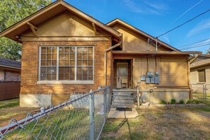 A two-story house with a brick facade, a large window, and a garage door. - < 1 Mi to Dtwn Texarkana: Couple's Retreat w/ Yard (Texarkana)