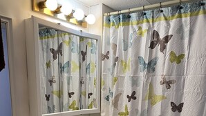 Un baño con lavamanos, espejo e inodoro.