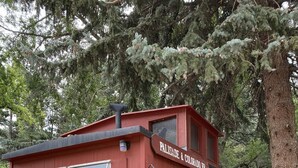 Un edificio de madera rojo con un letrero que dice "PALISADE & COLORADO RR", un pequeño porche y una banca.
