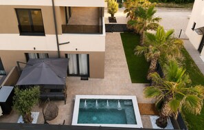 A rooftop pool with a patio area, surrounded by palm trees and a small garden. - 1 bedroom awesome apartment in Privlaka (Privlaka)