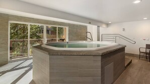 A modern spa area with a hot tub, large windows, and a balcony. - Fallridge Condo - Close to Bus & Nordic Center (Vail)