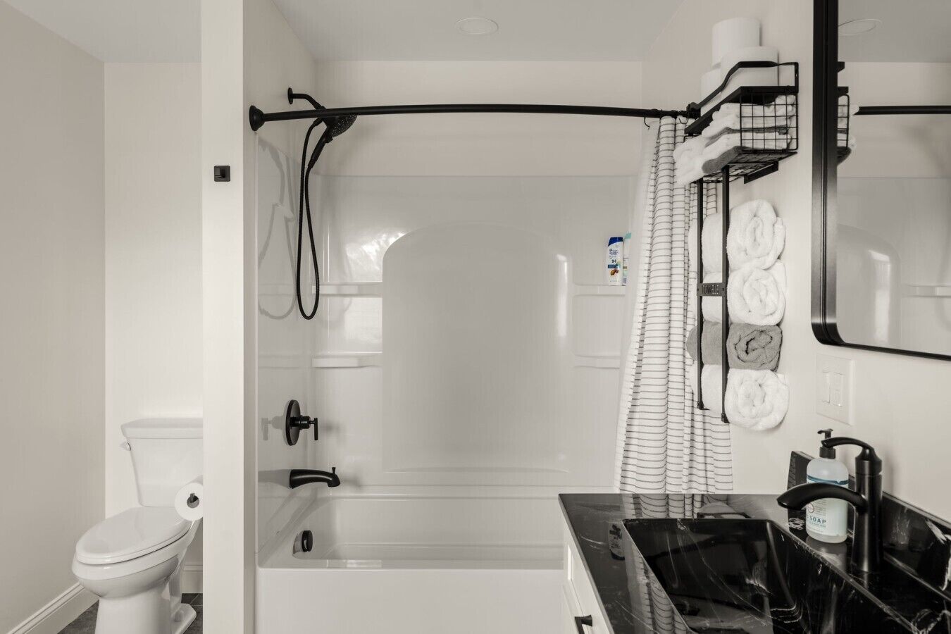 A bathroom with a shower, toilet, and sink.
