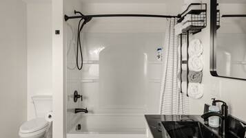 A bathroom with a shower, toilet, and sink.