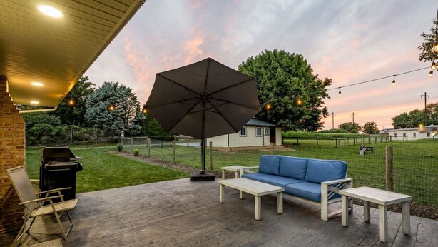 An outdoor patio with a barbecue grill, a blue sofa, and an umbrella. - Farm Views | 10min to Sight & Sound (Ronks)