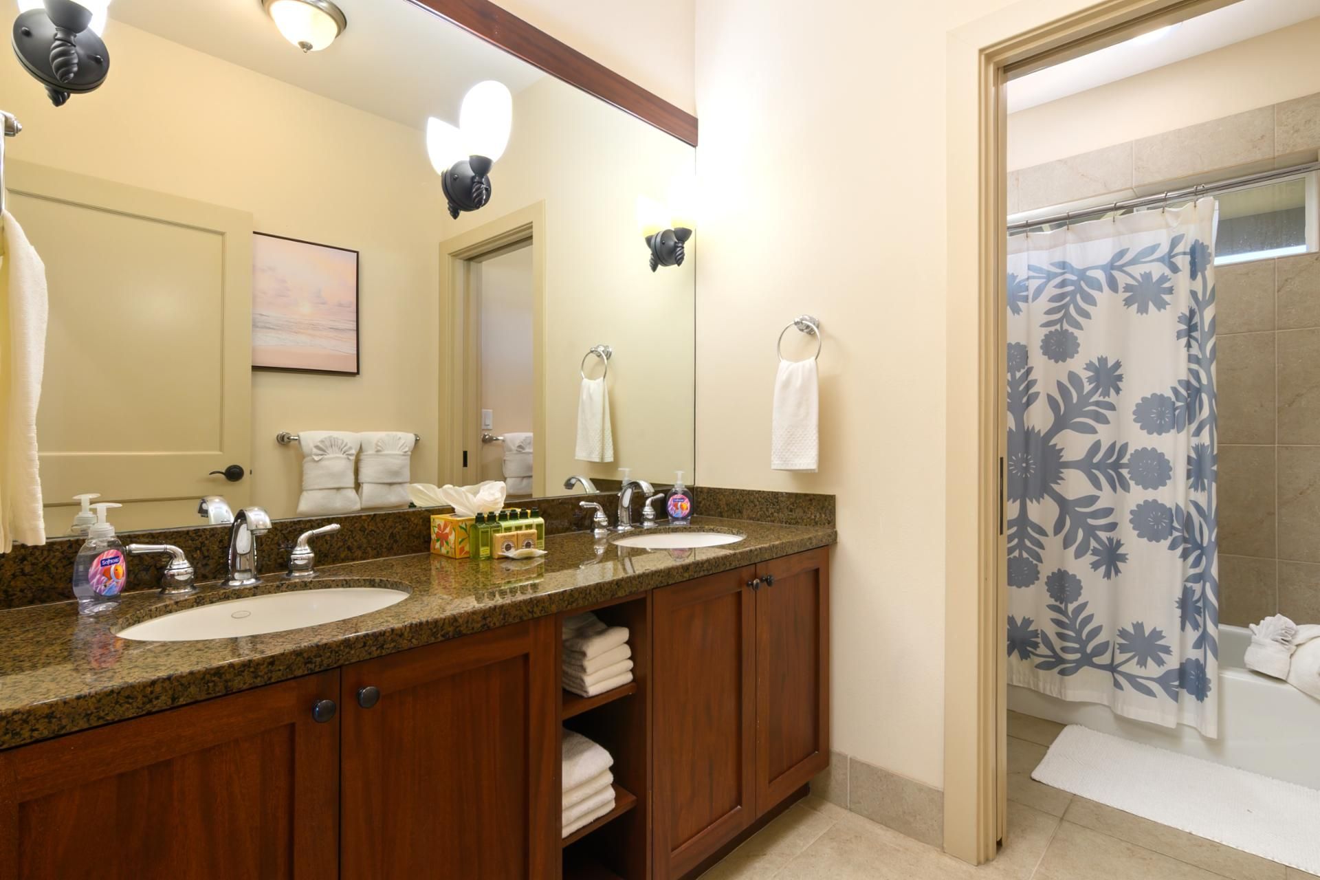 A bathroom with two sinks, a mirror, and a shower curtain.