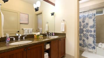 A bathroom with two sinks, a mirror, and a shower curtain.