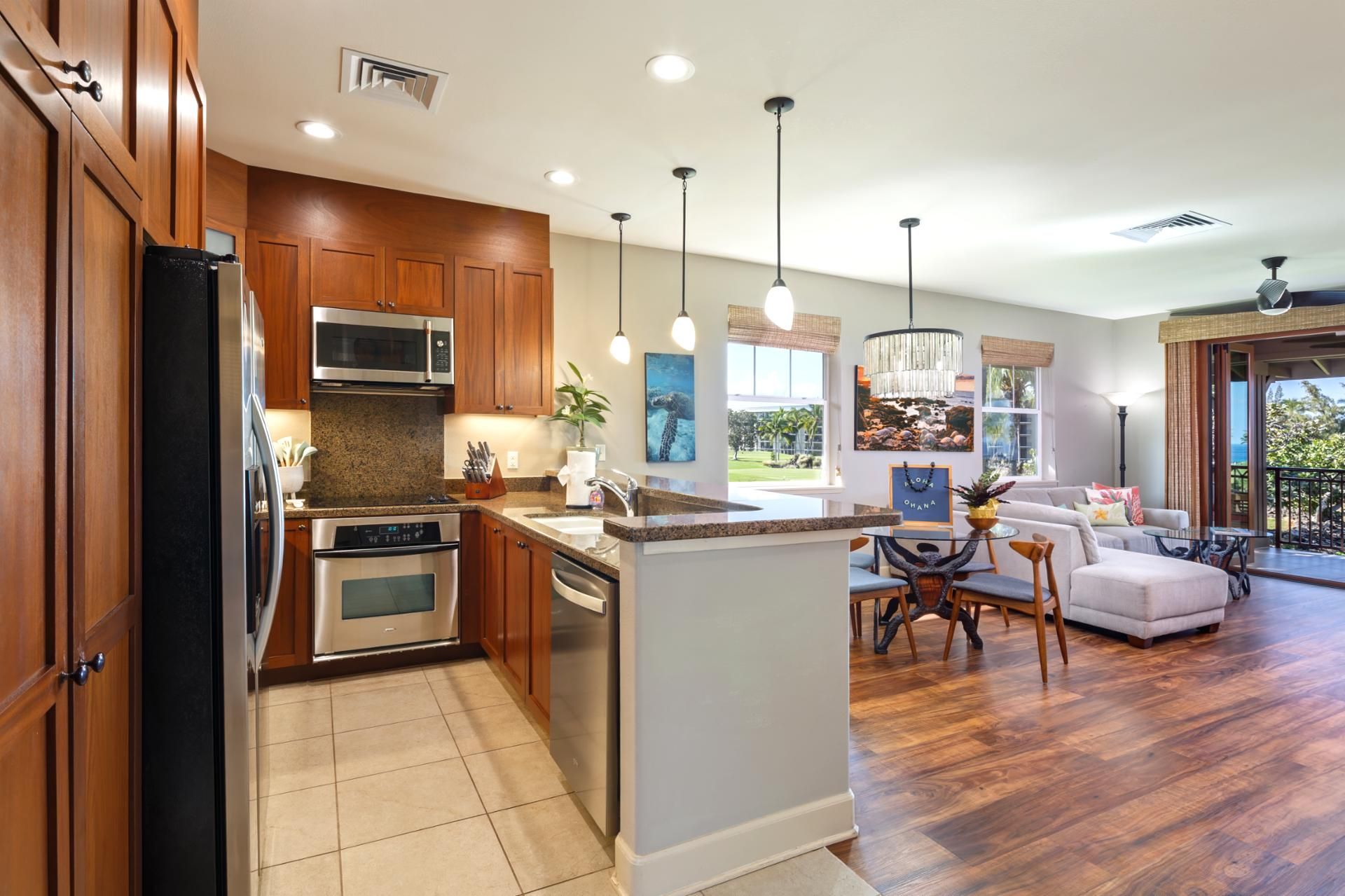 A modern kitchen with wooden cabinets, stainless steel appliances, and pendant lighting.