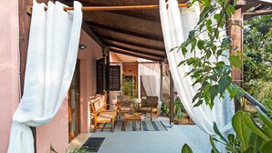 An outdoor seating area with two wooden chairs and a table, a covered pergola, and a view of the garden. - 2 bedroom lovely apartment in Bale (Bale)