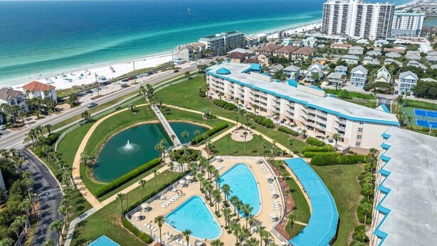 A resort with multiple swimming pools, a beach, and high-rise buildings in the background. - Amalfi Coast 318b (Miramar Beach)