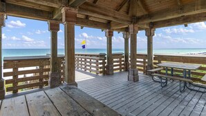 A wooden deck with picnic tables and a railing overlooking a beach. - Amalfi Coast 318b (Miramar Beach)