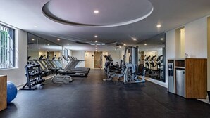 Een moderne sportschool met loopbanden, gewichtstoestellen en fitnessballen.