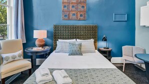 A hotel room with a large bed, two bedside tables, a chair, and a desk. - Walk to Coffee, Dining & Campus | Historic Studio (Columbia)