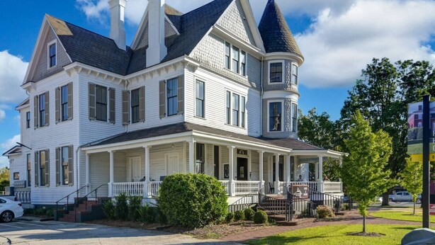 A large, two-story Victorian-style house with a wrap-around porch and a turret. - Walk to Coffee, Dining & Campus | Historic Studio (Columbia)