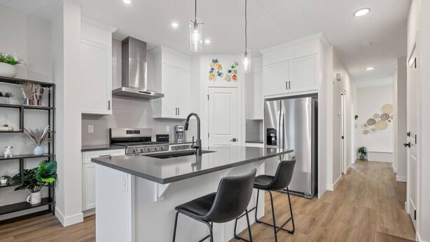 Een moderne keuken met een centraal kookeiland, roestvrijstalen apparatuur en een minimalistisch design.