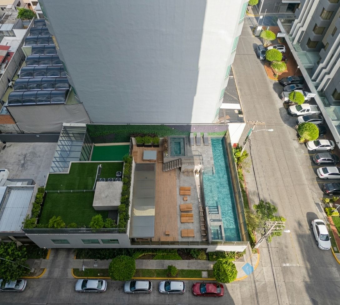 A modern building with a rooftop pool, a covered patio, and a parking area.