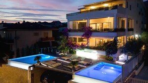 A modern two-story building with a swimming pool and lounge area. - Gorgeous home in Podstrana (Podstrana)