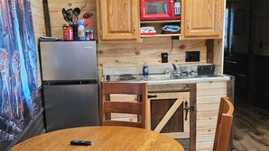 A cozy kitchen with wooden cabinets, a microwave, and a refrigerator.