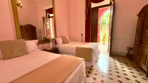 A hotel room with two beds, a large mirror, a wooden wardrobe, and a view of the outside. - La Casa Rosa Imperial (Mérida)