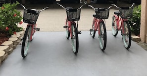 Three bicycles parked in a row on a concrete surface.