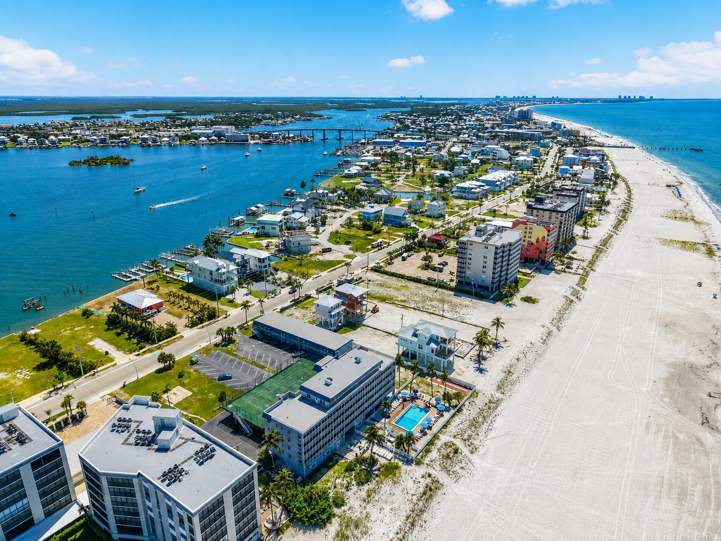 A coastal town with a marina, beachfront properties, and a prominent hotel with a pool.