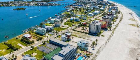A coastal town with a marina, beachfront properties, and a prominent hotel with a pool.