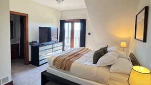 A bedroom with a bed, bedside table, lamp, ceiling fan, and a TV in a corner. - The Redwood Estate - Events on 25 Acres of Serenity (Aubrey)