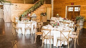 A rustic dining area with wooden tables and chairs, a staircase, and a wooden wall. - The Redwood Estate - Events on 25 Acres of Serenity (Aubrey)