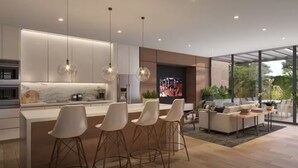 A modern kitchen with a central island, bar stools, pendant lighting, and a large TV screen. - Deluxe apartment near the Airport entire rental unit (Guatemala)
