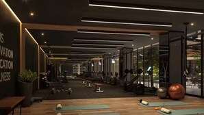 A modern gym with wooden flooring, exercise mats, and various fitness equipment. - Deluxe apartment near the Airport entire rental unit (Guatemala)