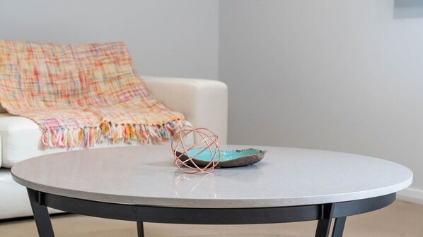A round table with a metal base, a decorative copper wire object, and a turquoise ceramic piece on top. - Sea Views set atop a hill in Kiama (Kiama)