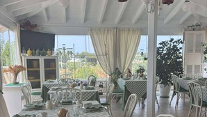 A restaurant with checkered tablecloths, white chairs, and a view of the sea. - 4 minutes from the historic center of Ostuni Family apartment with swimming pool (Ostuni)