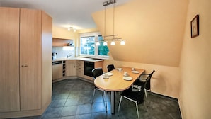 A compact kitchen with a dining area, featuring a window, a built-in oven, and a modern light fixture. - 1 bedroom pet friendly apartment in Röbel (Röbel)