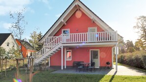 A two-story house with a balcony, a patio with outdoor furniture, and a well-maintained lawn. - Amazing apartment in Röbel with sauna (Röbel)