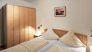 A bedroom with a bed, a nightstand, a lamp, a wardrobe, and a framed picture on the wall. - 1 bedroom beautiful apartment in Röbel (Röbel)